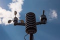 Home weather station on a background of blue sky with the sun behind the clouds. Measurement of temperature, humidity and wind dir