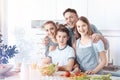 Radiant family posing for camera while cooking