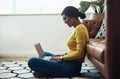 Home is where I feel most comfortable. Full length shot of an attractive young woman sitting alone at home and using her Royalty Free Stock Photo