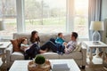 Home is where love lives. a happy young family of four relaxing together on the sofa at home. Royalty Free Stock Photo