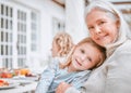 Home is where you are loved. a grandma and granddaughter cuddling at a table outside.