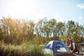 Home is where your tent is. an adventurous setting up their tent by the lake.