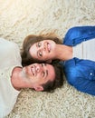 Home is wherever you are. High angle shot of an affectionate young couple lying on their living room floor. Royalty Free Stock Photo