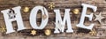 Home - white letters with gold christmas decoration on old wood Royalty Free Stock Photo