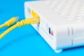 Home wireless router with ethernet cable plugged in on blue background, closeup Royalty Free Stock Photo