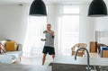 Home workout in the living room. Young muscular body man doing arm exercises using dumbbells. Healthy lifestyle or sporty people Royalty Free Stock Photo