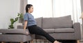 Home Workout of Young asian woman doing triceps dips on sofa watching fitness video tutorial online Royalty Free Stock Photo