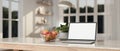 Home workspace with laptop mockup, apple bowl and decor plant on kitchen countertop