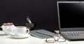 Home workspace for work or study in Office interior. Black laptop on white table black background. Glasses, cup of coffee, office Royalty Free Stock Photo