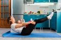 Home yoga. A young Caucasian mother does an exercise, putting the baby on her stomach. Side view. The concept of sports activity Royalty Free Stock Photo