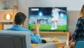 At Home Young Couple Watches Tense Moment of Soccer Match on TV, They Worry, Guy Trying to be Pati Royalty Free Stock Photo