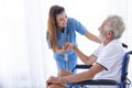 Homecare nurse staff take care elder male sitting at wheelchair happy smile together at home