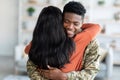 Homecoming Concept. Happy Black Soldier Man Embracing Wife After Turning Back Home