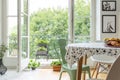 Homegrown herbs on a beautiful balcony outside a scandinavian dining room interior with a round table