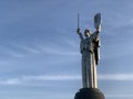 Homeland, high sculpture of a woman. Metal monument against the blue sky. Concept: sights of Kiev