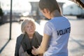 Homeless aged pensioner talking to volunteer in the street