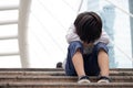 Homeless Asian child sitting alone on the stairway in the street. Poor, sad, scared and alone Royalty Free Stock Photo
