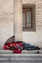 Homeless barefooted man sleeps on a stairway Royalty Free Stock Photo