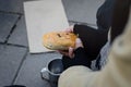 A homeless beggar eating bread and asking for help from passersby Royalty Free Stock Photo