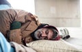 Homeless beggar man lying on the ground outdoors in city, sleeping. Royalty Free Stock Photo