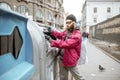 Homeless beggar near the trash containers in the city Royalty Free Stock Photo