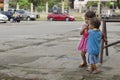 Homeless beggar`s children boy and girl, walking, take care of each other at church yard