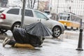 Homeless beggar with umbrella in the rain