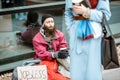 Homeless begging money to a passing by woman