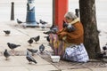 Homeless begging woman pigeons