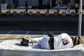 A homeless black man asleep on the old sofa in the street