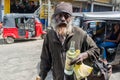 Homeless dirty old man with beard and bottle in the hand at the street