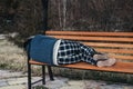 homeless elderly old man lies sleeping on park bench in autumn