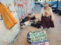 Homeless elderly sad woman begging money for her hungry dogs and cats on the streets of Kiev