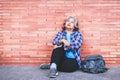 Homeless elderly woman sitting on the floor of the corridor