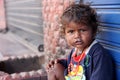 Homeless girl looks cute and friendly have running nose, Wear dirty clothes sitting on the street.