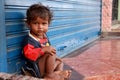 Homeless girl looks cute and friendly have running nose, Wear dirty clothes sitting on the street.