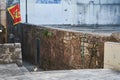 Homeless gray one-eyed cat sits on stone steps in Herceg Novi Royalty Free Stock Photo