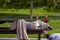 A homeless guy is sleeping on a picnic bench at a park