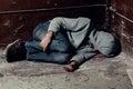 Homeless guy sleeps on the floor in the slums