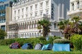 Homeless image with shelter tents against an expensive hotel background