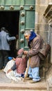 Homeless indian woman begs for money in front of the church in