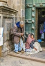 Homeless indian woman begs for money in front of the church in