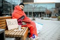 Homeless beggar on the bench near the business center Royalty Free Stock Photo