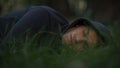 Homeless male sleeping on grass in park, poverty and social issues concept Royalty Free Stock Photo