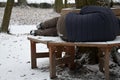 Homeless man, abandoned lonely and frail. When spending the night in a park on a snowy circle shape bench, it can get cold or caus Royalty Free Stock Photo