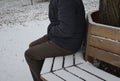 Homeless man, abandoned lonely and frail. When spending the night in a park on a snowy circle shape bench, it can get cold or caus Royalty Free Stock Photo