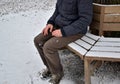 Homeless man, abandoned lonely and frail. When spending the night in a park on a snowy circle shape bench, it can get cold or caus Royalty Free Stock Photo