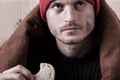 Homeless man eating a piece of bread