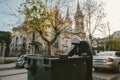 Homeless man looking into trash box in search for food on church background. Homelessness problem concept Royalty Free Stock Photo