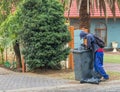 Homeless man picking through refuse bin for leftovers